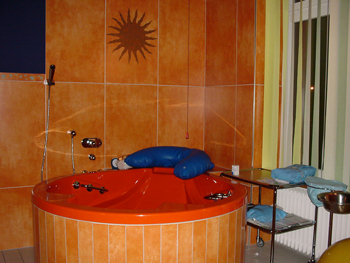 In warmen Farben gehaltener Gebärsaal mit Badewanne 